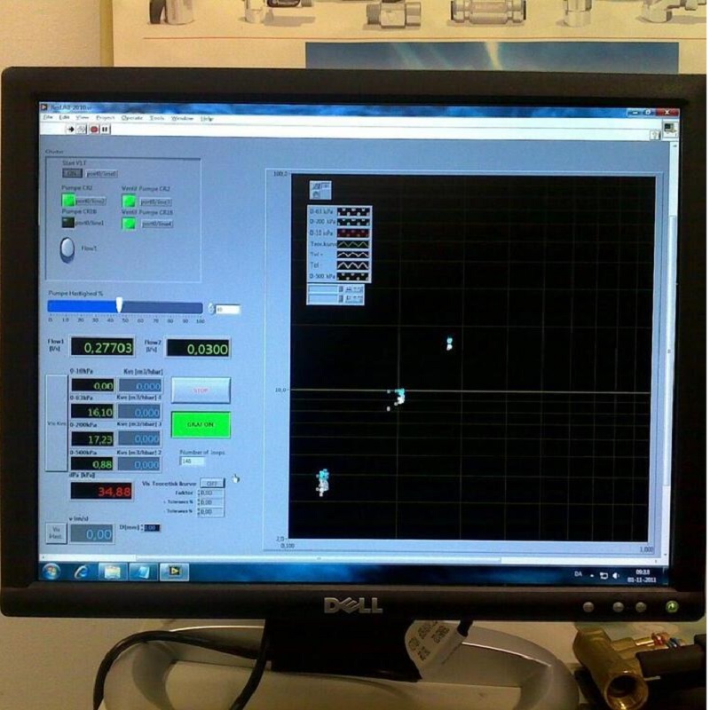 computer monitor displaying a software interface, likely used for industrial or scientific purposes. The screen features a control panel on the left with various parameters and readings, including flow rates (e.g., 0.27703 and 0.0300 m³/h), pressure values (e.g., 16.10 kPa and 17.23 kPa), and other metrics like temperature (34.88°C). The interface includes buttons like "START," "STOP," and "GRAFIKON" (likely "Graph" in a different language). On the right side, there is a graph or visualization area with a grid, displaying a few data points or a small plot, possibly representing real-time data from a pump or flow system. The monitor is a Dell model, and the setup appears to be in a technical or laboratory environment, with a diagram or equipment illustration visible in the background.